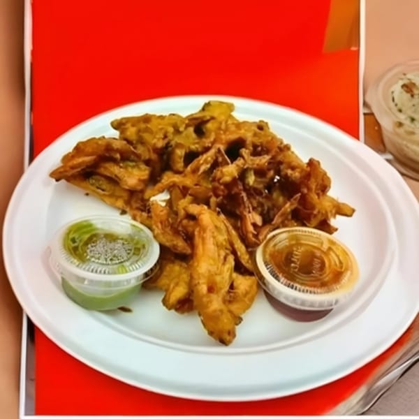 Spicee Bite's Indian pakora, a plate of fried fritters with green and brown dipping sauces.